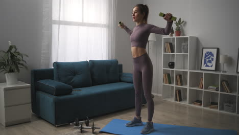 athletic-woman-is-training-alone-in-living-room-home-fitness-exercises-with-dumbbells-workout-in-apartment-keeping-fit-and-losing-weight